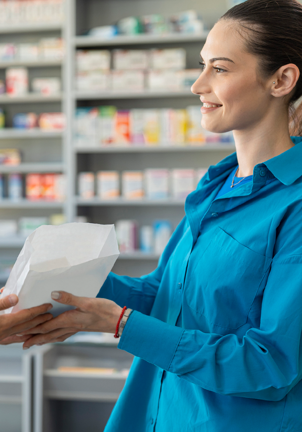 A costumer in a blue jacket accepting their prescription at a pharmacy